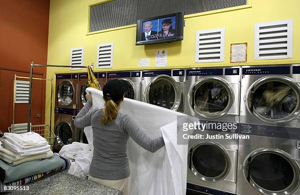 Woman folds clothes as she watches the vice presidential debate with Republican U.S. Vice presidential Candidate Alaska Gov. Sarah Palin and...