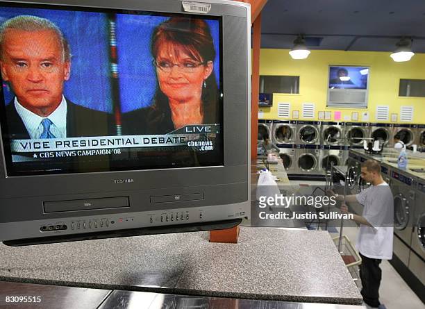 Man walks in a laundry mat as a television plays the vice presidential debate with Republican U.S. Vice presidential Candidate Alaska Gov. Sarah...