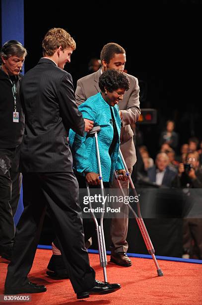 Journalist and debate moderator Gwen Ifill is helped onto the stage before the vice presidential debate at the Field House of Washington University's...