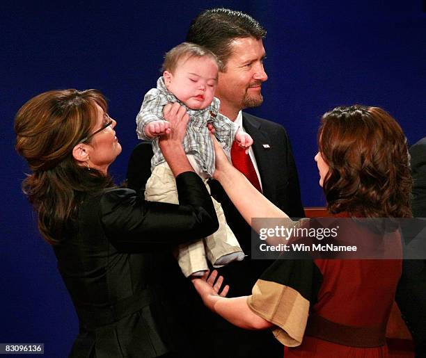 Republican vice presidential candidate Alaska Gov. Sarah Palin hands her son Trigg to her daughter Willow Palin as husband Todd Palin looks on after...