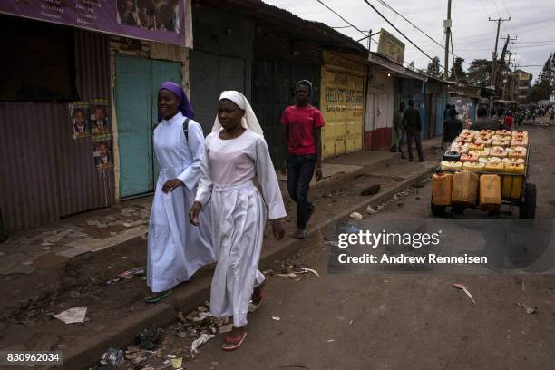 Women walk to church in the Kibera slum on August 13, 2017 in Nairobi, Kenya. A day prior, demonstrations turned violent in some areas throughout...