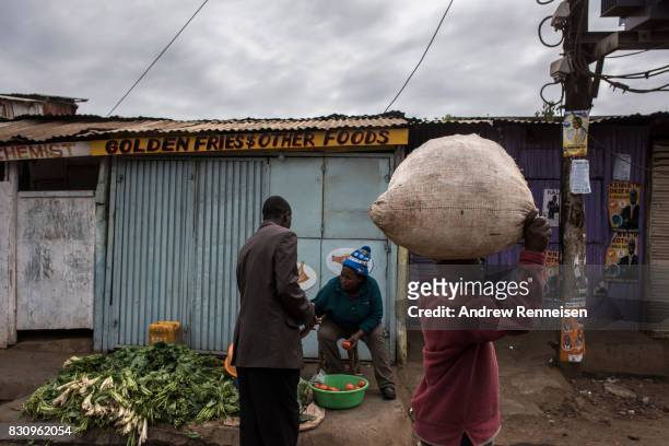 Woman sells vegetables in the Kibera slum on August 13, 2017 in Nairobi, Kenya. A day prior, demonstrations turned violent in some areas throughout...