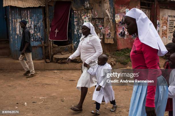 Women and children walk to church in the Kibera slum on August 13, 2017 in Nairobi, Kenya. A day prior, demonstrations turned violent in some areas...