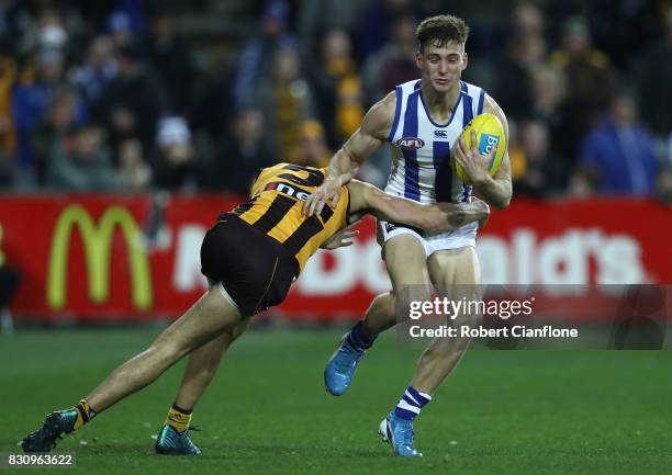 Shaun Atley of the Kangaroos is challenged by Ryan Burton of the Hawks during the round 21 AFL match between the Hawthorn Hawks and the North...