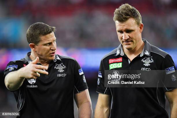 Magpies midfield coach Scott Burns and Magpies head coach Nathan Buckley walk from the field during the round 21 AFL match between Port Adelaide...