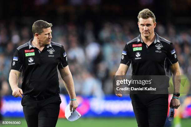 Magpies midfield coach Scott Burns and Magpies head coach Nathan Buckley walk from the field during the round 21 AFL match between Port Adelaide...