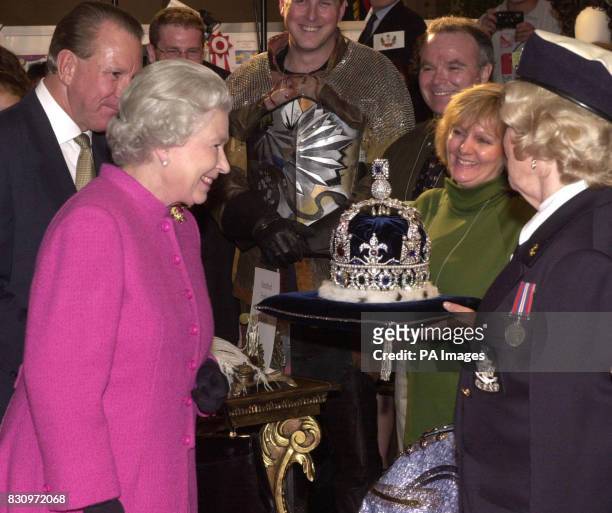 Queen Elizabeth II, accompanied by the premier of Ontario, Ernie Eves , looks at a replica of the Imperial State Crown, which was on a display by the...