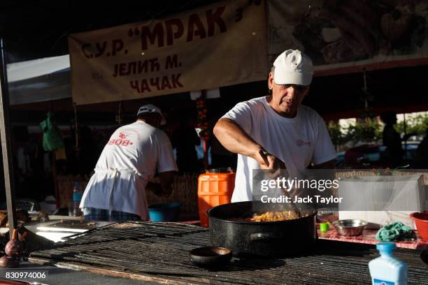 Cook prepares food on a grill during the Guca Trumpet Festival on August 10, 2017 in Guca, Serbia. Thousands of revellers attend the trumpet...