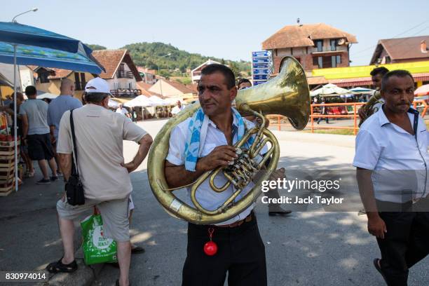 Musicians carry their instruments through the streets during the Guca Trumpet Festival on August 10, 2017 in Guca, Serbia. Thousands of revellers...