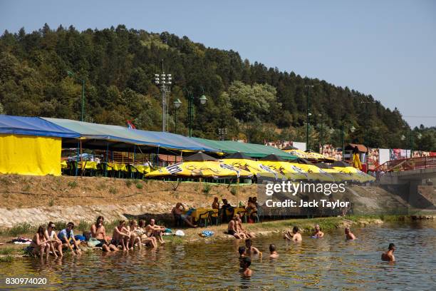 People cool off in the Bjelica river during the Guca Trumpet Festival on August 10, 2017 in Guca, Serbia. Thousands of revellers attend the trumpet...