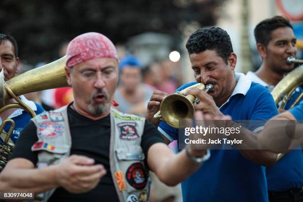 Man dances as a brass band play in the street during the Guca Trumpet Festival on August 10, 2017 in Guca, Serbia. Thousands of revellers attend the...