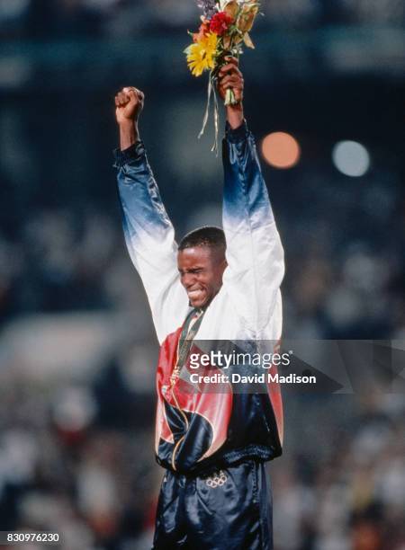 Carl Lewis of the USA celebrates his Olympic gold medal in the Men's Long Jump event of the Athletics Competition of the 1996 Summer Olympics on July...