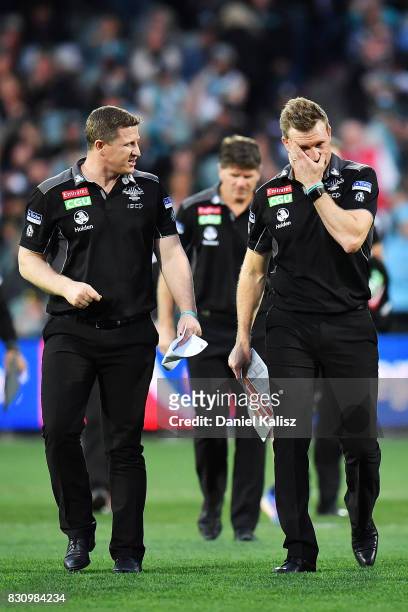 Magpies midfield coach Scott Burns chats with Magpies head coach Nathan Buckley during the round 21 AFL match between Port Adelaide Power and the...