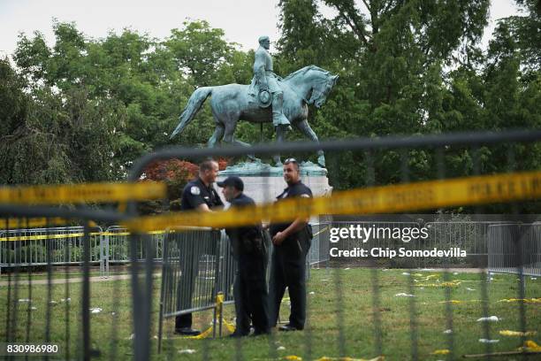 Police stand watch near the statue of Confederate Gen. Robert E. Lee in the center of Emancipation Park the day after the Unite the Right rally...