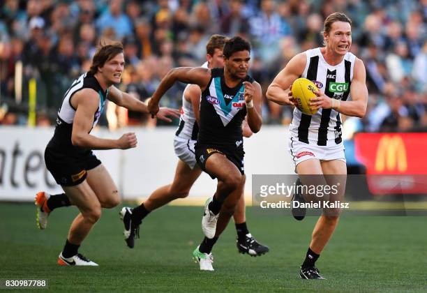 Tom Langdon of the Magpies runs with the ball during the round 21 AFL match between Port Adelaide Power and the Collingwood Magpies at Adelaide Oval...