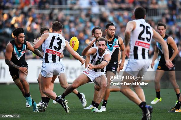 Lynden Dunn of the Magpies handballs during the round 21 AFL match between Port Adelaide Power and the Collingwood Magpies at Adelaide Oval on August...