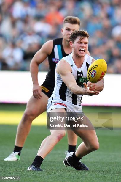 Jordan De Goey of the Magpies handballs during the round 21 AFL match between Port Adelaide Power and the Collingwood Magpies at Adelaide Oval on...