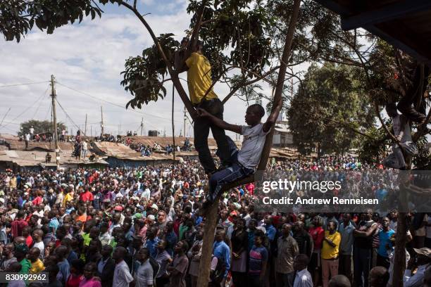 Supporters look on as opposition candidate Raila Odinga addresses a crowd in the Kibera slum on August 13, 2017 in Nairobi, Kenya. A day prior,...