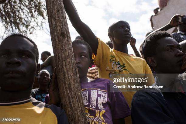 Supporters look on as opposition candidate Raila Odinga addresses a crowd in the Kibera slum on August 13, 2017 in Nairobi, Kenya. A day prior,...