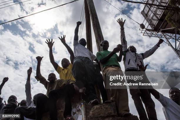 Supporters cheer as opposition candidate Raila Odinga addresses a crowd in the Kibera slum on August 13, 2017 in Nairobi, Kenya. A day prior,...