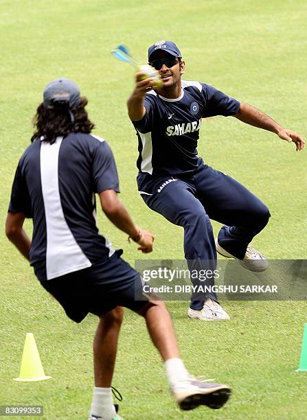 Indian cricketer Mahendra Singh Dhoni and teammate Ishant Sharma play in a game of throw ball during a training session at the Chinnaswamy Stadium in...