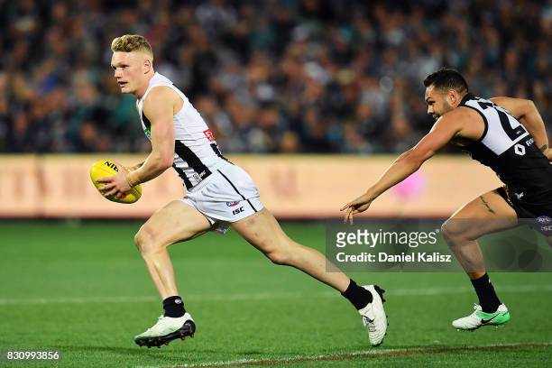 Adam Treloar of the Magpies runs with the ball during the round 21 AFL match between Port Adelaide Power and the Collingwood Magpies at Adelaide Oval...
