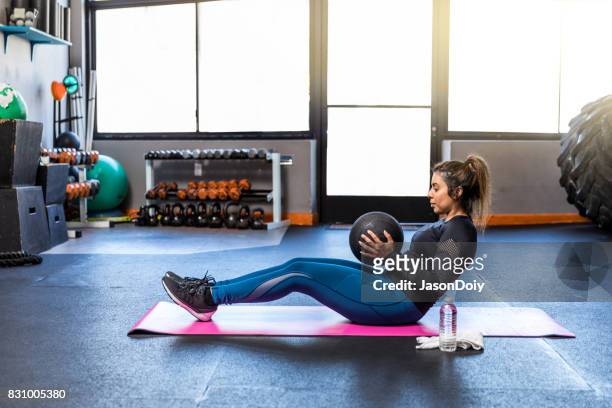 cross training sit-ups mit medizinball in ein fitness-studio - hiit stock-fotos und bilder