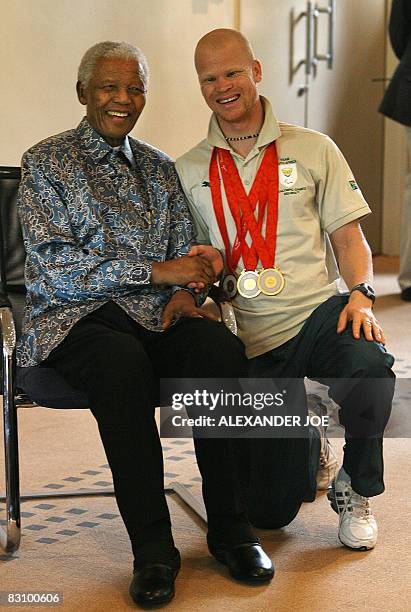 Triple gold at the Paralympic Games 2008, Hilton Langenhoven smiles as he poses with South Africa's first democratic leader Nelson Mandela on October...