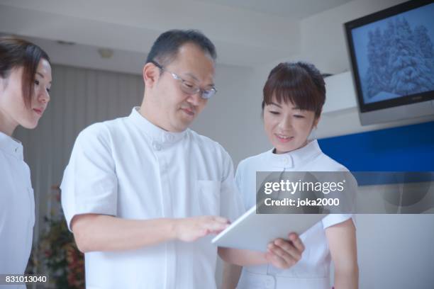 medical staffs talking about data at clinic - 職場 stock pictures, royalty-free photos & images