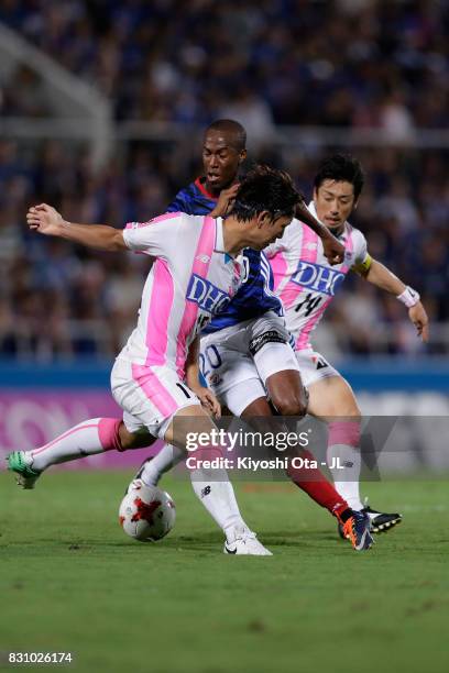 Martinus of Yokohama F.Marinos competes for the ball against Jung Seung Hyun and Yoshiki Takahashi of Sagan Tosu during the J.League J1 match between...