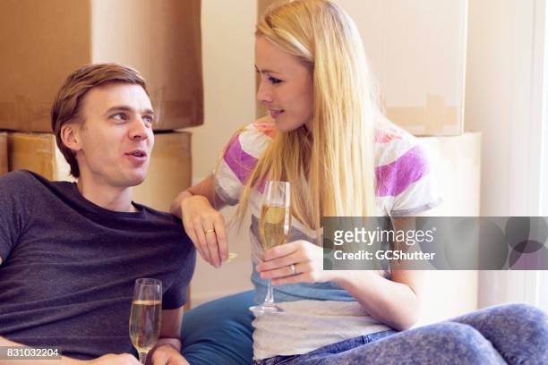 recém casados relaxar após um dia de descompactar com champanhe - drinks carton - fotografias e filmes do acervo