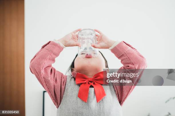 cute asian girl finishing her glass of milk, feeling happy and satisfied - 3 d glasses foto e immagini stock