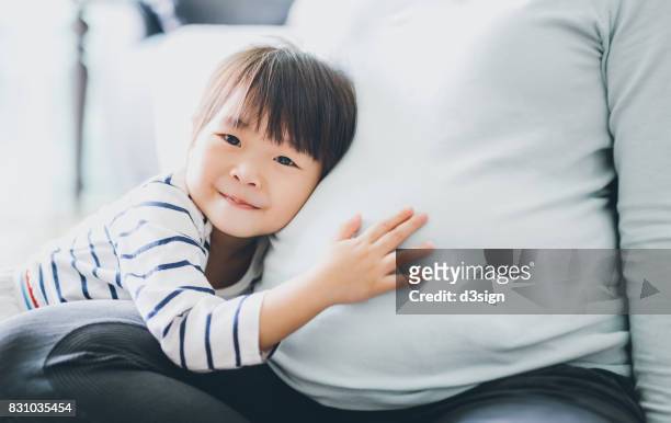 cute little asian girl touching and listening to pregnant mother's belly with joy - little kids belly imagens e fotografias de stock