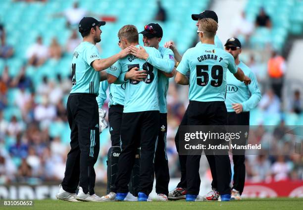 Sam Curran of Surrey celebrates with his teammates after bowling out Luke Wright of Sussex during the NatWest T20 Blast match between Surrey and...