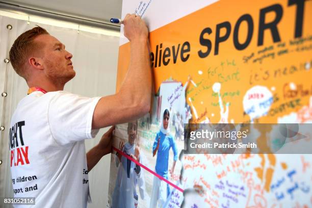 Olympic and World Champion Long Jumper Greg Rutherford writes a message as he attends a Right To Play event during day ten of the 16th IAAF World...