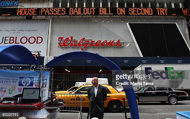 Man looks on beneath a Times Square news ticker announcing the Congressional bailout bill passage October 3, 2008 in New York City. Congress passed a...