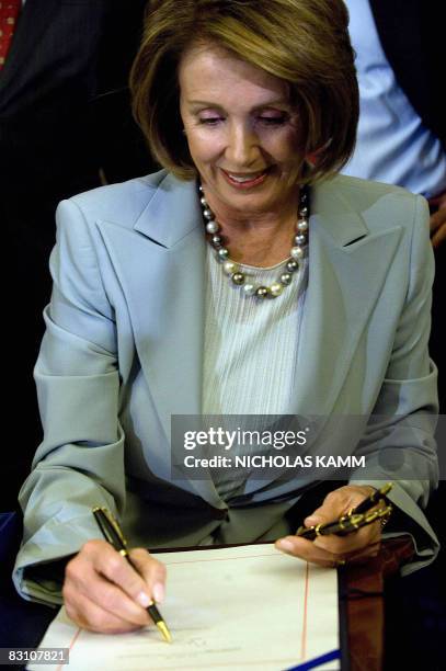 Speaker of the House Nancy Pelosi signs the revised 700-billion-USD Wall Street bailout bill during a press conference October 3, 2008 in Washington,...