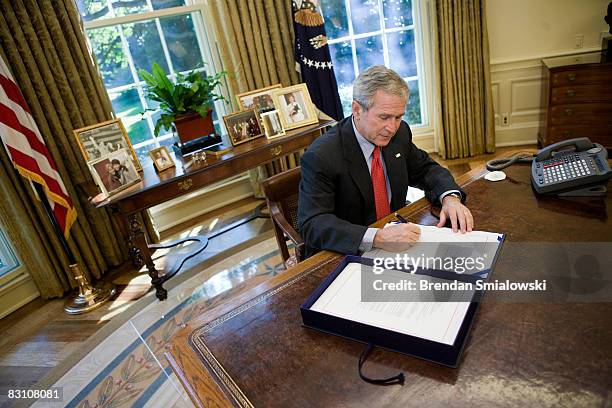 President George W. Bush signs a Wall Street bailout bill in the Oval Office of the White House October 3, 2008 in Washington, DC. Bush signed the...