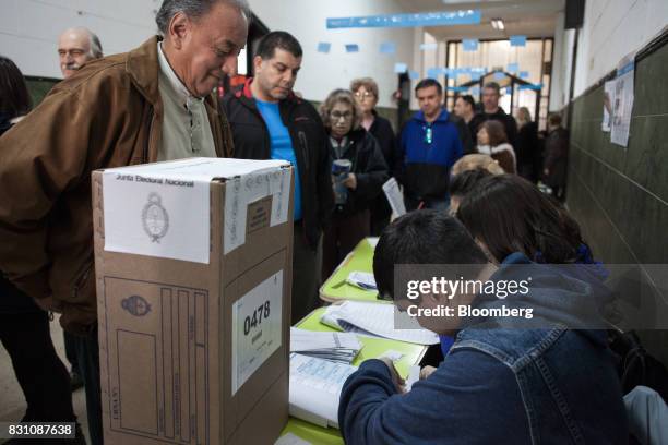 Voter checks in at a polling center before casting a ballot during a primary election in Buenos Aires, Argentina, on Sunday, Aug. 13, 2017....