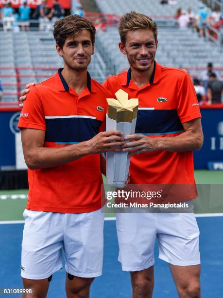 Pierre-Hugues Herbert and Nicolas Mahut of France pose with the trophy after defeating Rohan Bopanna of India and Ivan Dodig of Croatia 6-4, 3-6,...