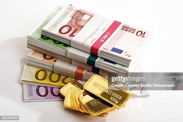 gold bars and euro notes - bundle stock-fotos und bilder