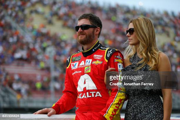 Dale Earnhardt Jr., driver of the Axalta Chevrolet, stands on the grid with his wife, Amy Reimann, prior to the Monster Energy NASCAR Cup Series Pure...