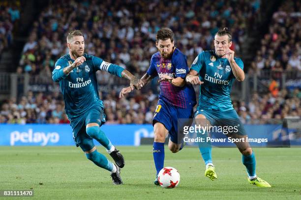 Lionel Messi of FC Barcelona dribbles Gareth Bale and Sergio Ramos of Real Madrid during the Supercopa de Espana Final 1st Leg match between FC...