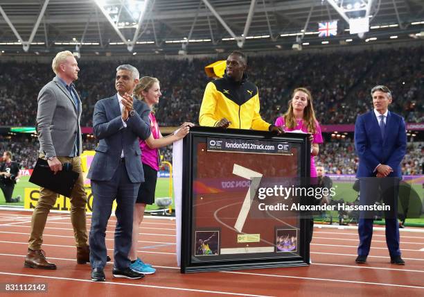 Usain Bolt of Jamaica is presented with a framed piece of the track from the London 2012 Olympics IAAF President Sebastian Coe and Mayor of London...