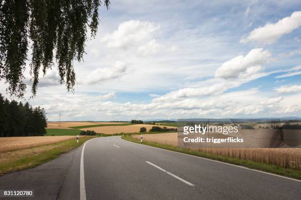 farmland with big blue sky - country road stock pictures, royalty-free photos & images