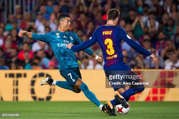 Cristiano Ronaldo of Real Madrid CF shoots the ball under pressure from Gerard Pique of FC Barcelona during the Supercopa de Espana Supercopa Final...