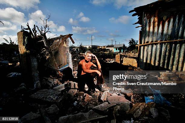 Roberto Velazquez, 49-years-old, sits atop a pile of ruble of what used to be his house after Hurricane Ike tore through a week earlier September 15,...