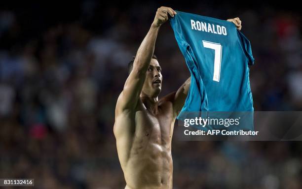 Real Madrid's Portuguese forward Cristiano Ronaldo takes off his jersey to celebrate his goal during the first leg of the Spanish Supercup football...