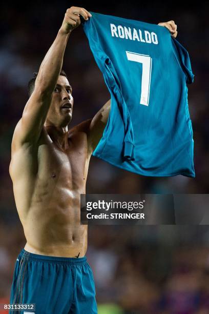 Real Madrid's Portuguese forward Cristiano Ronaldo takes off his jersey to celebrate his goal during the first leg of the Spanish Supercup football...