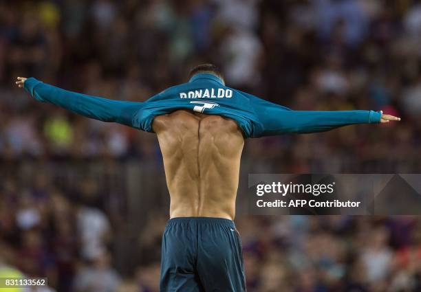Real Madrid's Portuguese forward Cristiano Ronaldo puts on his jersey after celebrating his goal during the first leg of the Spanish Supercup...